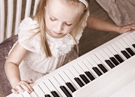 little girl playing on piano