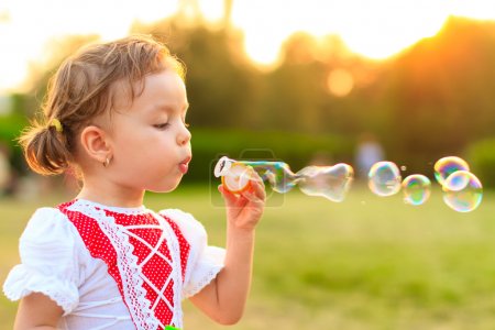 Child blowing soap bubbles.