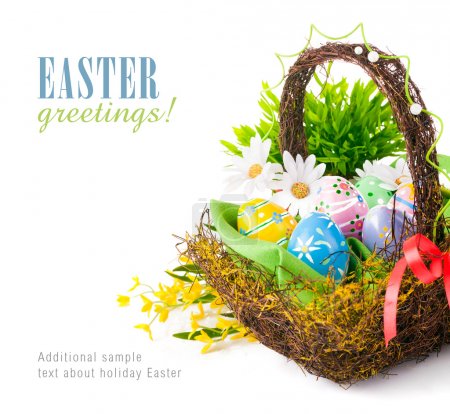 Easter eggs in basket with spring flowers