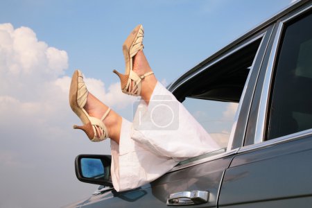 Female feet in window of car