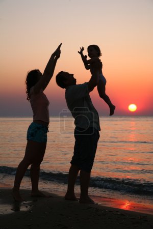 Mummy with daughter and grandfather on sunset ashore