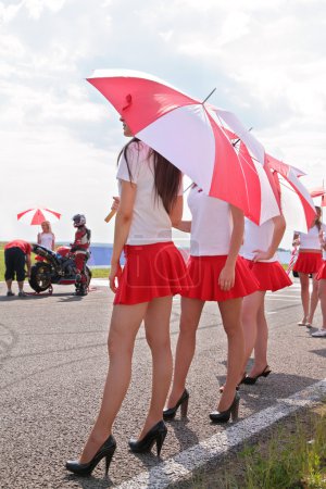 Paddock-girls with umbrellas