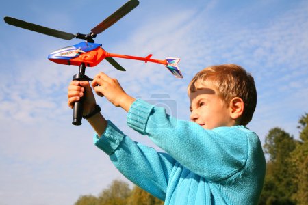 Boy starts toy helicopter