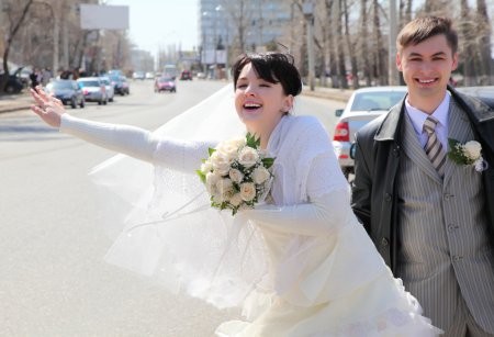 Bride with fiance on street stops car
