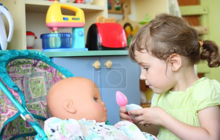 Little girl feeds doll