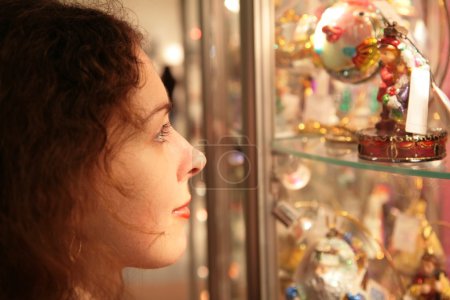 Young woman looks on showcase with souvenirs