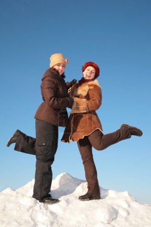 Two young woman posing on snow hill