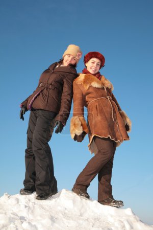 Two young woman posing on snow hill 2
