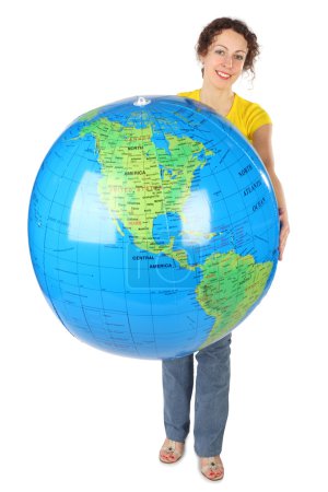 Young curl woman in yellow shirt holding big globe, smiling and