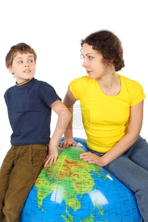Mother and son sitting on big inflatable globe and looking to ea