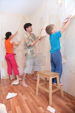 Mother with father and son break wallpapers from wall