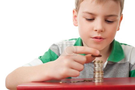 Boy in striped T-shirt stacking up coins isolated on white bac