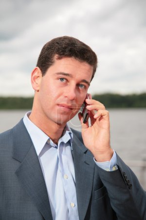 Portrait of man near pond, which speaks on cell phone