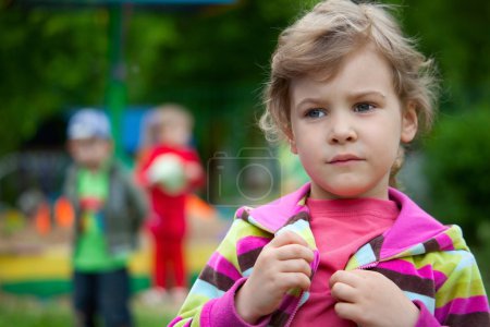 The girl plays in a court yard in kindergarten
