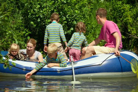 Children and adults float on an inflatable boat
