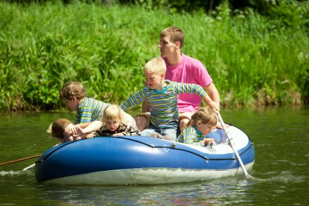 Children go for a drive on an inflatable boat under supervision