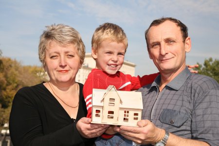Grandmother and grandfather with grandson and model of the house