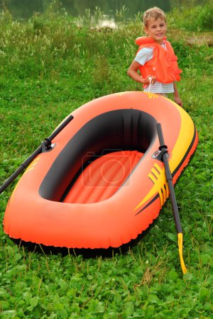Boy and inflatable boat on lawn