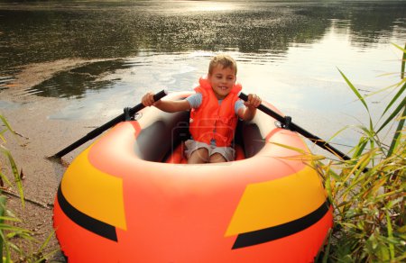 Boy in inflatable boat in water