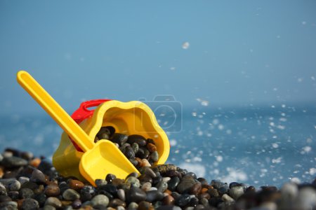 Yellow children's bucket with scoop on seacoast
