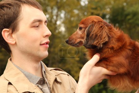 Young man and his adorable dachshund closeup