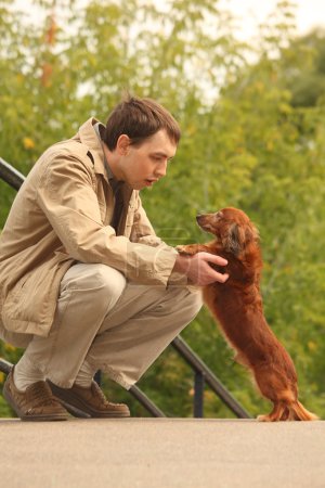 Young man and his adorable dachshund outdoor