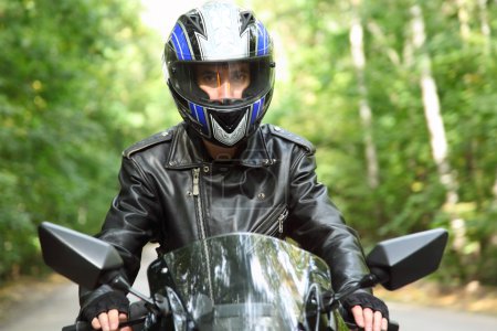Motorcyclist goes on road, front view, closeup