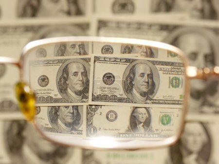 Dollars by the closeup through the eyeglasses