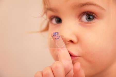 Little girl and finger with painted face