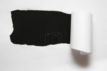 The sheet of torn paper against the black background