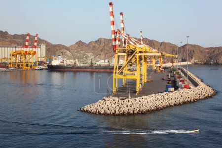 Yellow cranes in shipping port near mountains summer day