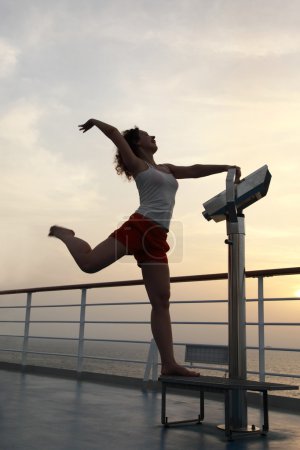 Girl practise gymnastics exercises at ship deck full body