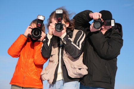 Three photographers against blue sky