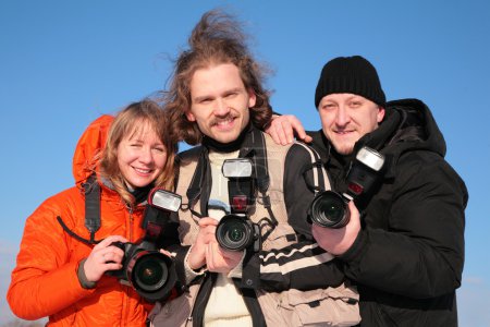 Three fotographers against blue sky 2
