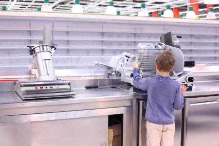 Boy stands at scales in empty shop