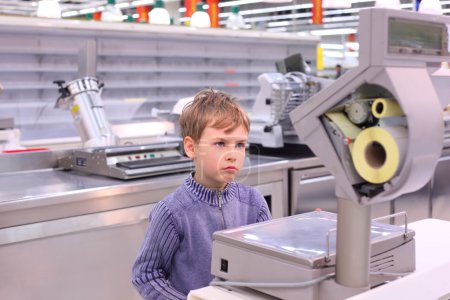 Boy looks at scales in empty shop