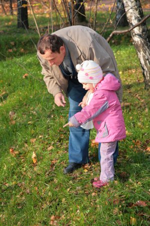 Grandfather with granddaughter outdoor look downward