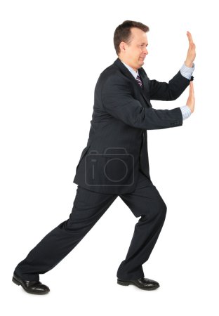 Businessman rests hands against wall