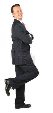 Happy businessman stands on one leg