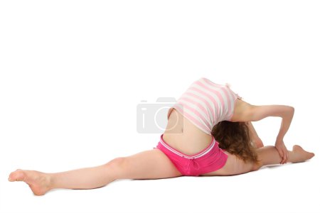 Girl in sportswear does gymnastic exercise on floor