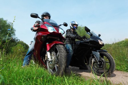 Two motorcyclists standing on country road, bottom view