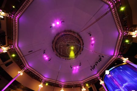 Circus interior view on celling with pink light lamps and blue c