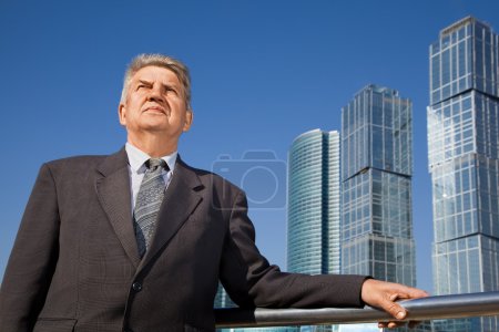 Senior man near skyscrapers construction