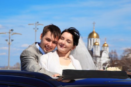 Bride with fiance against church