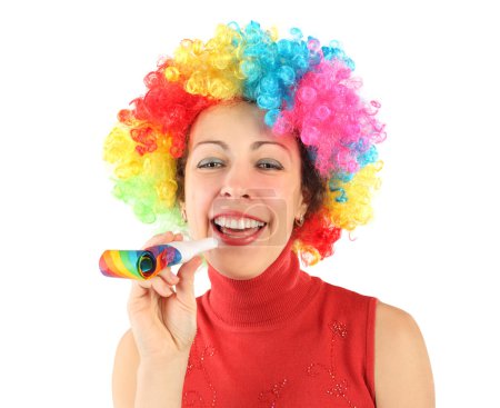 Young beauty woman in clown wig and with party blower, laughing