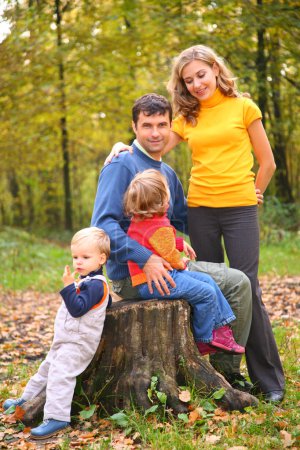 Parents with children in forest in autumn