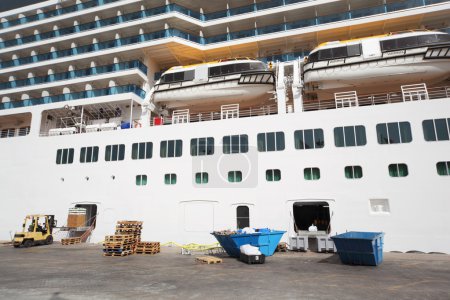 Large white passenger liner loading at dock summer day