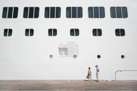 Little boy and girl near large white passenger liner at dock sum