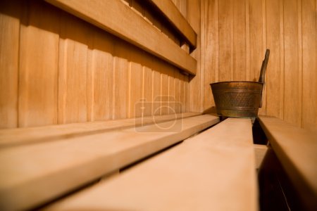 Bench in sauna and copper bucket