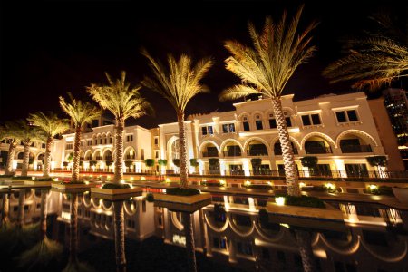 Night Dubai street with palms and pool, United Arab Emirates